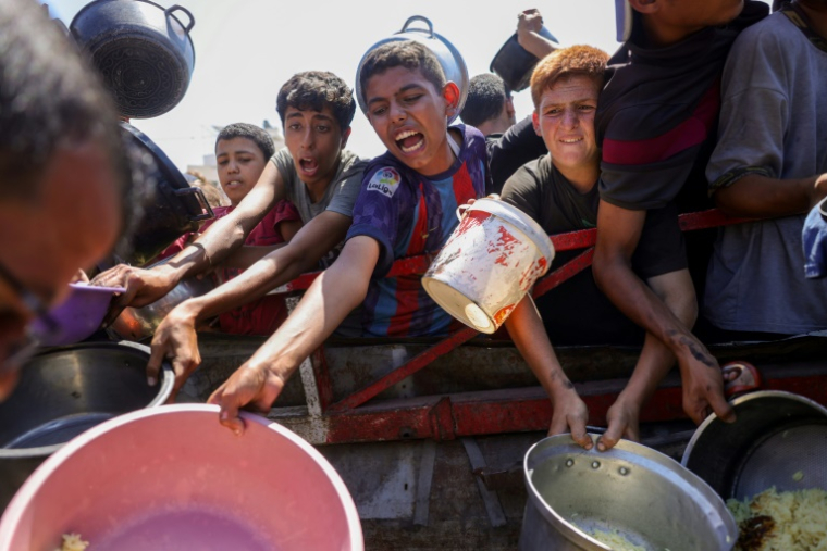 Des jeunes Palestiniens tentent d'obtenir du riz distribué par une cuisine caritative dans l'ouest de Gaza, le 28 août 2025 ( AFP / BASHAR TALEB )