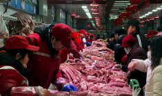 Des vendeurs de porc s'occupent des clients dans un marché à Pékin