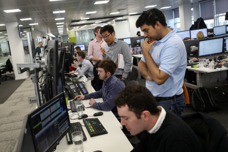 Les traders consultent des informations financières dans la salle des marchés d'IG Index