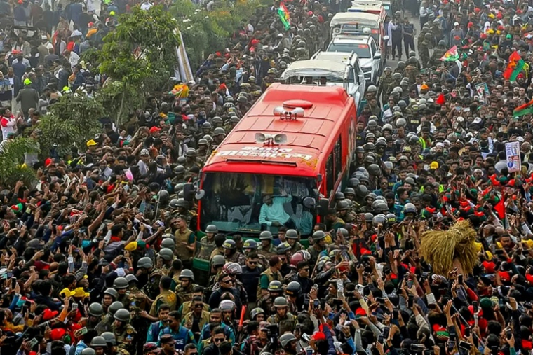 Photo prise et diffusée le 25 décembre 2025 par la cellule médias du Parti nationaliste du Bangladesh (BNP) sur sa page Facebook officielle, montrant le président par intérim du BNP, Tarique Rahman (c), saluant ses partisans depuis un bus à son arrivée à Dacca, au Bangladesh ( Cellule médias du Parti nationaliste du Bangladesh (BNP) / - )