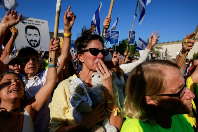 Une femme émue sur la place des Otages à Tel-Aviv, après l'annonce des libérations d'otages retenus par le Hamas à Gaza, le 13 octobre 2025 ( AFP / Menahem Kahana )