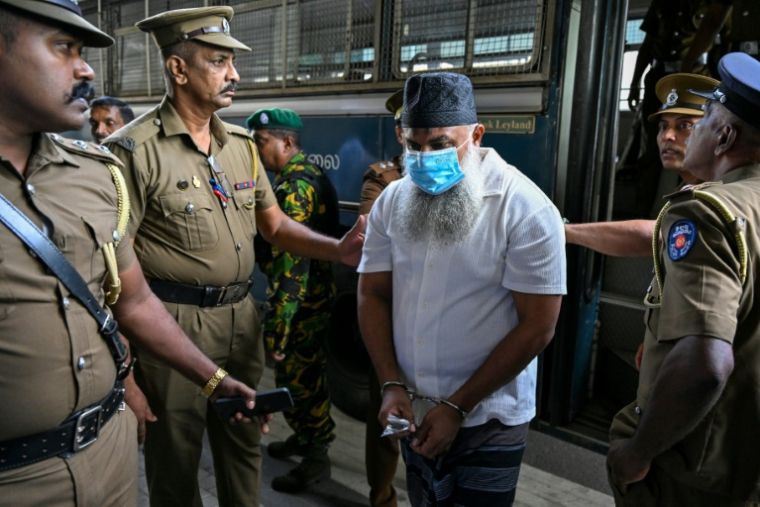 Des policiers escortent les accusés impliqués dans les attentats de Pâques 2019, lors du prononcé du verdict à la Haute Cour de Colombo, le 22 septembre 2026 au Sri Lanka ( AFP / Ishara S. KODIKARA )