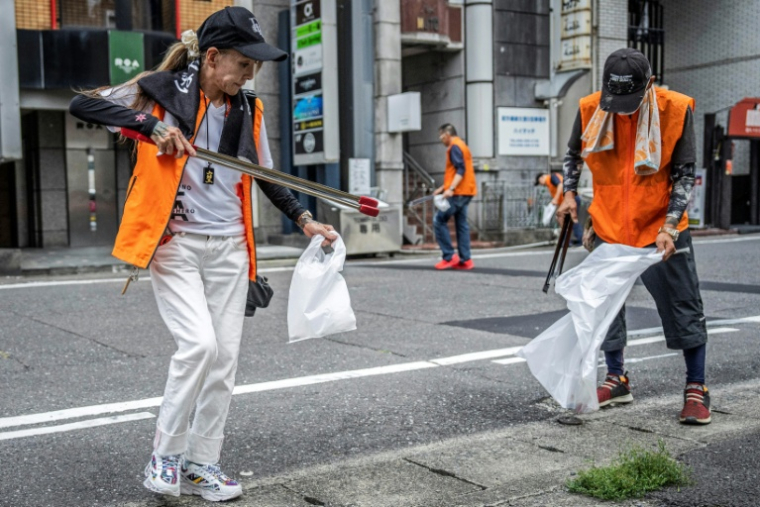 Mako Nishimura (g), yakuza à la retraite, collecte des déchets avec des anciens délinquants lors de leur opération mensuelle de ramassage de déchets à Gifu, le 28 septembre 2025 au Japon ( AFP / Yuichi YAMAZAKI )