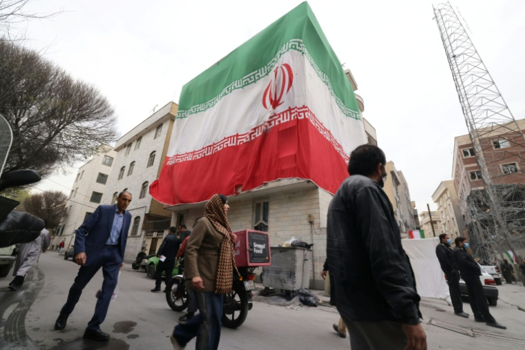 Un drapeau iranien géant déployé sur la façade d'un immeuble à Téhéran, le 15 mars 2026 ( AFP / Atta KENARE )