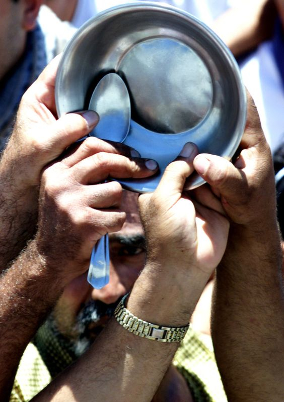 Des Palestiniens tiennent des assiettes et des cuillères vides