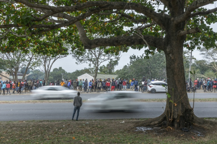 Des centaines d'étrangers déplacés ayant fui les violences antimigrants attendent de monter à bord de bus pour quitter leur camp de fortune de Sherwood Park à Durban (Afrique du Sud), le 16 juin 2026 ( AFP / RAJESH JANTILAL )