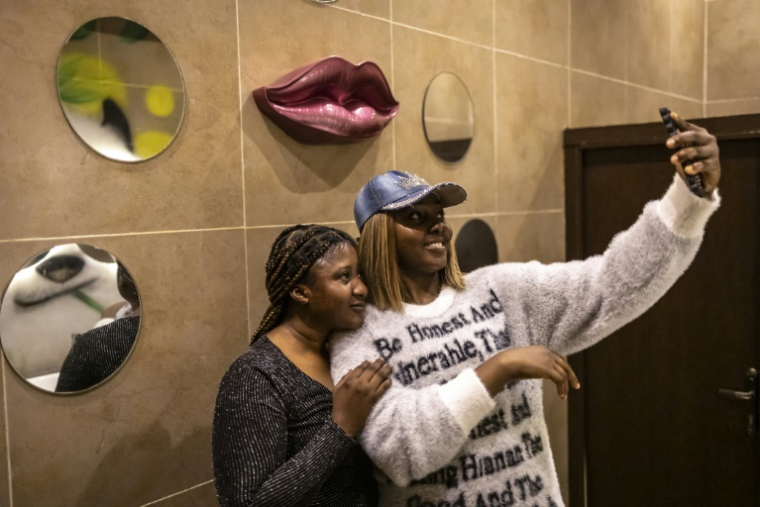 Deux clientes se prennent en photo dans les toilettes du restaurant Antika à Kano, le 10 septembre 2025 au Nigeria ( AFP / OLYMPIA DE MAISMONT )