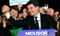 Nicusor Dan salue ses partisans après l'annonce de sa victoire à la présidentielle roumaine, le 18 mai 2025 à Bucarest ( AFP / Daniel MIHAILESCU )