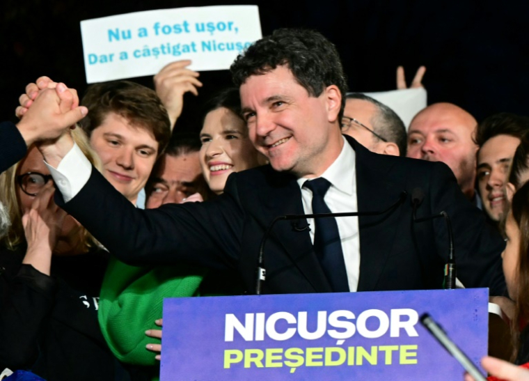 Nicusor Dan salue ses partisans après l'annonce de sa victoire à la présidentielle roumaine, le 18 mai 2025 à Bucarest ( AFP / Daniel MIHAILESCU )