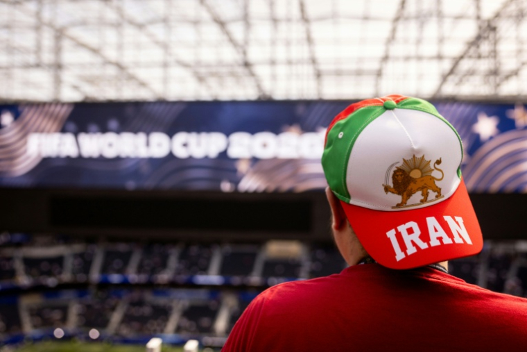 Un spectateur porte une casquette avec le drapeau utilisé par l'Iran avant la révolution islamique, et un drapeau israélien, à l'intérieur du SoFi Stadium à Inglewood, près de Los Angeles, le 15 juin 2026 ( AFP / ETIENNE LAURENT )