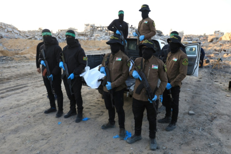 Des militants du Hamas et du Jihad islamique portent un sac contenant la dépouille d'un otage, à Beit Lahia, dans le nord de la bande de Gaza,le 3 décembre 2025 ( AFP / - )