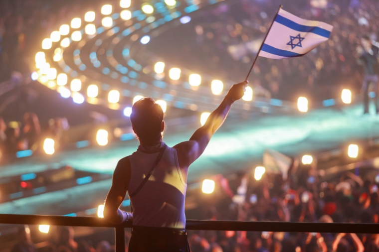 Un fan porte un drapeau israélien à Vienne, en Autriche, lors de la finale de l'Eurovision le 16 mai 2026. ( AFP / Radek MICA )