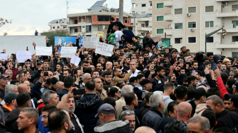Des personnes participent à une manifestation dans la ville côtière de Lattaquié, fief alaouite de Syrie, le 25 novembre 2025 ( AFP / Haidar MUSTAFA )