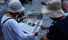 Des personnes réagissent en lisant une édition spéciale du journal Yomiuri Shimbun qui rapporte l'accord tarifaire entre les États-Unis et le Japon, à Tokyo