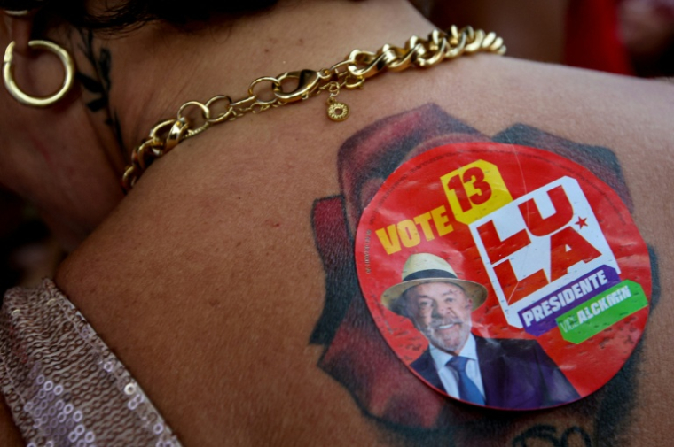 Une partisane du président brésilien Luiz Inacio Lula da Silva, montre un autocollant portant l'image de Lula dans son dos, à Brasilia, le 25 octobre 2026, lors du second tour de l'élection présidentielle. ( AFP / Igo ESTRELA )