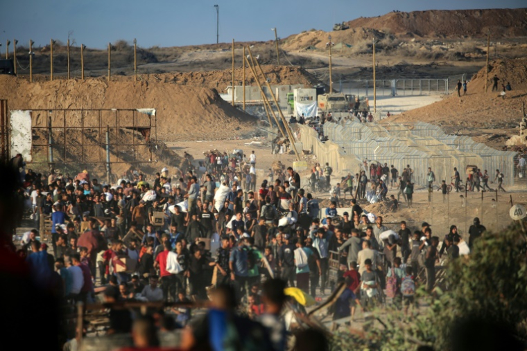 Des Palestiniens rassemblés à un point de distribution d'aide de la Fondation humanitaire de Gaza (GHF), près du camp de réfugiés de Nousseirat, dans le centre de la bande de Gaza, le 25 juin 2025 ( AFP / Eyad BABA )