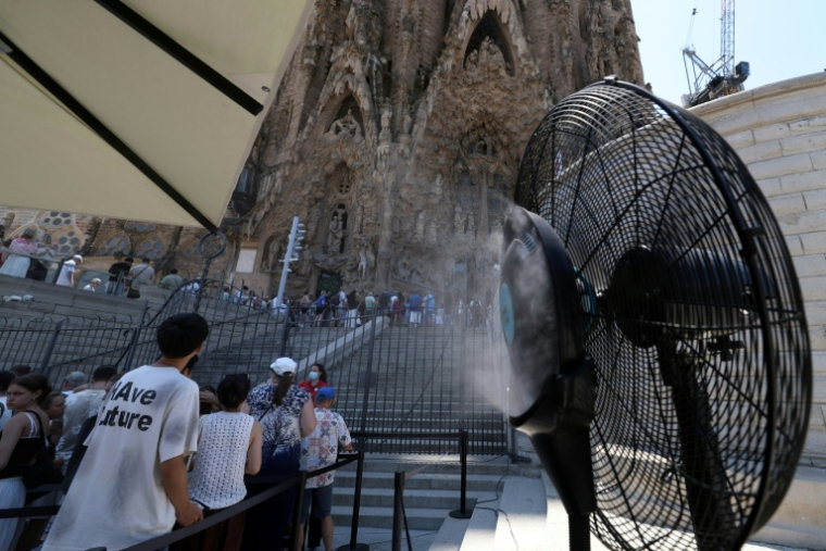 Un ventilateur brumisateur rafraîchit les touristes qui visitent la Sagrada Família à Barcelone, le 7 juillet 2026, lors d'une vague de chaleur en Espagne ( AFP / Lluis Gene )