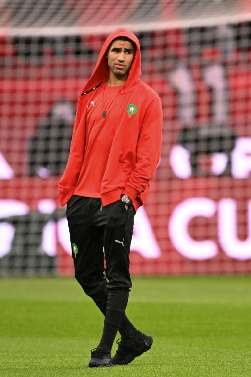 Achraf Hakimi sur la pelouse du stade Prince Moulay Abdallah avant le match d'ouverture de la CAN remporté 2-0 par le Maroc face aux Comores le 21 décembre 2025. Le latéral droit des Lions de l'Atlas et du Paris SG, sérieusement blessé à une cheville en novembre, se dit prêt mais il a été préservé pour ce premier match ( AFP / SEBASTIEN BOZON )