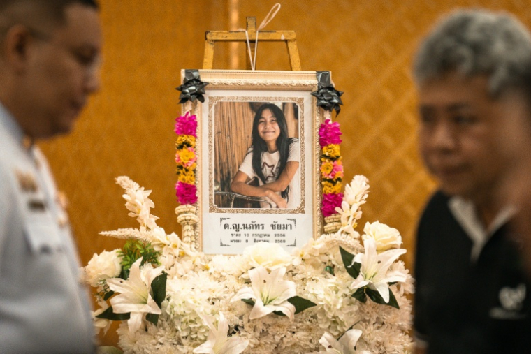 Un portrait de Naphat Chaima posé devant le cercueil de cette écolière de 12 ans, l'une des huit victimes de la fusillade survenue dans une école en Thaïlande, le 9 août 2026 dans un temple de Nonthaburi, au nord de Bangkok ( AFP / Chanakarn LAOSARAKHAM )