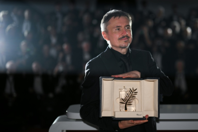 Le réalisateur roumain Cristian Mungiu pose avec la Palme d'Or pour son film "Fjord" lors de la cérémonie de clôture du 79e Festival de Cannes, le 23 mai 2026 ( AFP / Olivier CHASSIGNOLE )