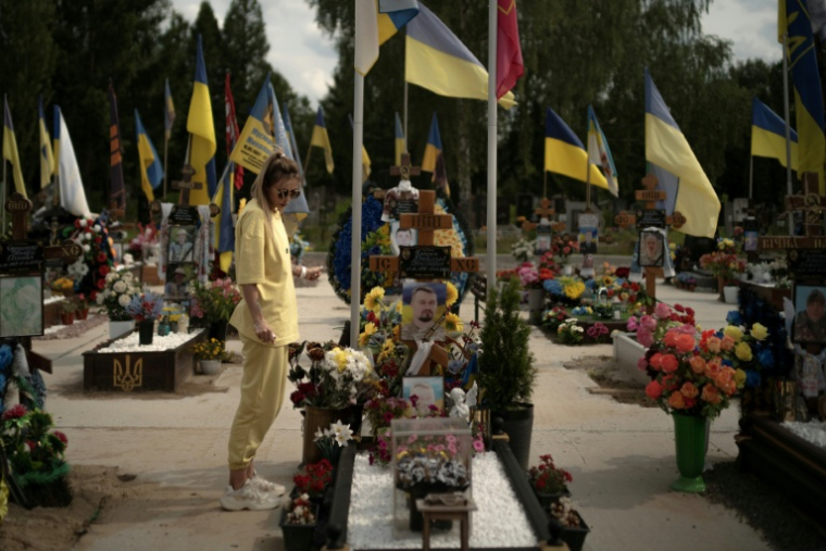 Une jeune femme se recueille devant la tombe d'un soldat au cimetière de Sumy, dans le nord-est de l'Ukraine le 11 juin 2025 ( AFP / Florent VERGNES )