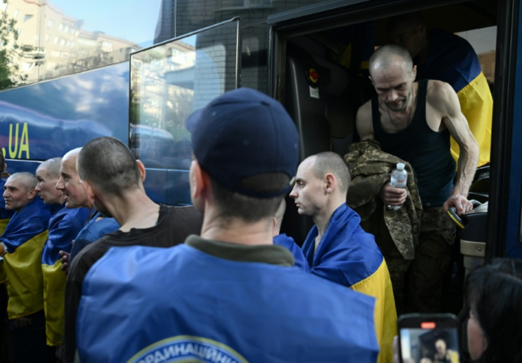 Des prisonniers ukrainiens descendent d'un bus à leur arrivée après un échange de prisonniers dans la région de Tcherniguiv, le 23 mai 2025 ( AFP / Genya SAVILOV )