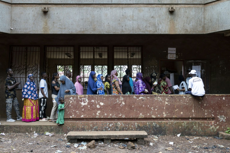 Des électeurs font la queue devant un bureau de vote installé dans une école primaire de la capitale guinéenne Conakry, le 21 septembre 2025. Les Guinéens ont voté en nombre dimanche sur un projet de Constitution soumis par la junte et visant au retour à l'ordre constitutionnel, quatre ans après la prise de pouvoir par les militaires ( AFP / PATRICK MEINHARDT )