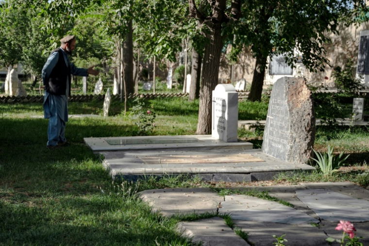 Le gardien Aynullah Rahimi devant des tombesd 'étrangers au cimetière britannique à Kaboul, le 22 mai 2025 en Afghanistan ( AFP / Wakil KOHSAR )