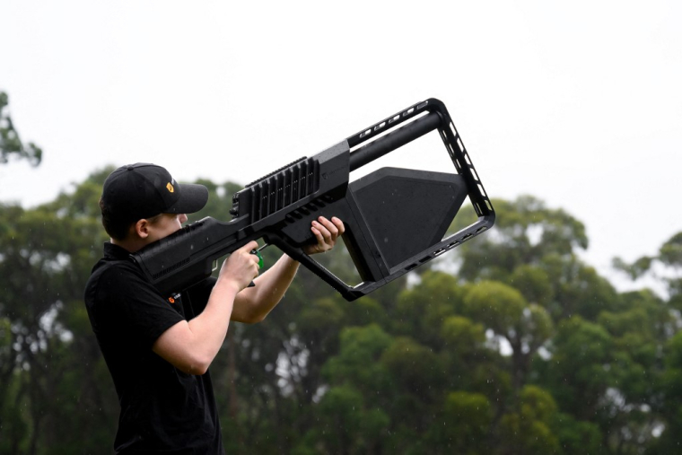 Un employé de Droneshield manipulant un fusil antidrone à Sydney, en Australie, le 9 février 2026. ( AFP / STEVEN MARKHAM )