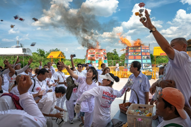 Des volontaires jettent des fleurs de santal lors de la cérémonie de Lang Pacha au complexe de la fondation Dhamma du Bouddha de la région de Nakhon Ratchasima, en Thaïlande, le 23 avril 2025 ( AFP / Chanakarn Laosarakham )