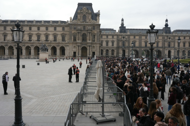 Des touristes massés devant des barrières de sécurité près du Louvre, à Paris, bloqué par des étudiants en art, le 19 octobre 2026 ( AFP / Dimitar DILKOFF )