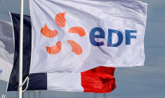Un drapeau portant le logo d'EDF et un drapeau français flottent à côté de la centrale EDF de Bouchain