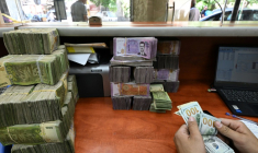 Un employé compte l'argent dans un bureau de change à Damas, le 21 mai 2025 ( AFP / LOUAI BESHARA )