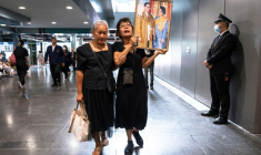 Des Thïlandaises tiennent des portraits de la reine mère Sirikit, le 25 octobre 2025 à l'hôpital Chulalongkorn de Bangkok où elle est décédée. ( AFP / Chanakarn Laosarakham )