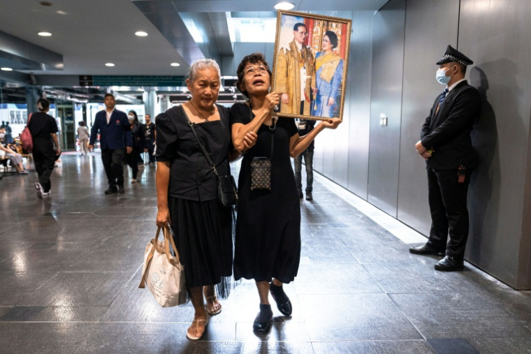 Des Thïlandaises tiennent des portraits de la reine mère Sirikit, le 25 octobre 2025 à l'hôpital Chulalongkorn de Bangkok où elle est décédée. ( AFP / Chanakarn Laosarakham )