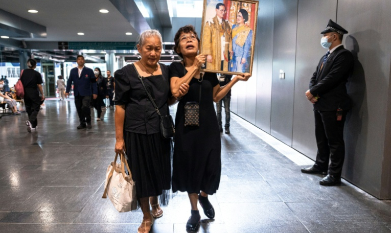 Des Thïlandaises tiennent des portraits de la reine mère Sirikit, le 25 octobre 2025 à l'hôpital Chulalongkorn de Bangkok où elle est décédée. ( AFP / Chanakarn Laosarakham )
