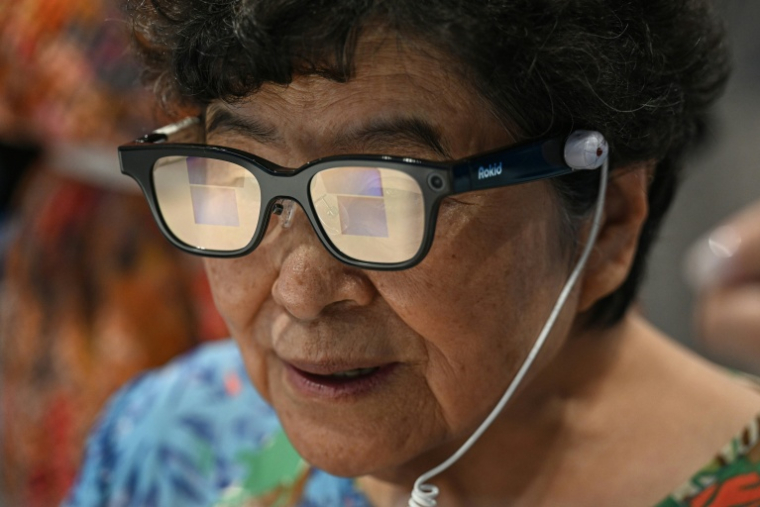 Une femme âgée en train d’essayer une paire de lunettes Rokid à intelligence artificielle à la Seoul Open City University, à Séoul, le 16 juillet 2026 ( AFP / Jade GAO )