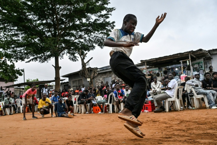 Un jeune homme fait une démonstration de biama, à Abidjan, le 19 août 2026 ( AFP / Issouf SANOGO )