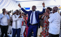 Le président élu du Gabon Brice Clotaire Oligui Nguema (Centre) lève les doigts au ciel, le 13 avril 2025 à Libreville, lors de l'annonce des résultats de l'élection présidentielle qui a mis fin à 19 mois de transition dans le pays ( AFP / Daniel BELOUMOU OLOMO )