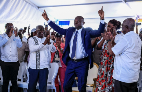 Le président élu du Gabon Brice Clotaire Oligui Nguema (Centre) lève les doigts au ciel, le 13 avril 2025 à Libreville, lors de l'annonce des résultats de l'élection présidentielle qui a mis fin à 19 mois de transition dans le pays ( AFP / Daniel BELOUMOU OLOMO )