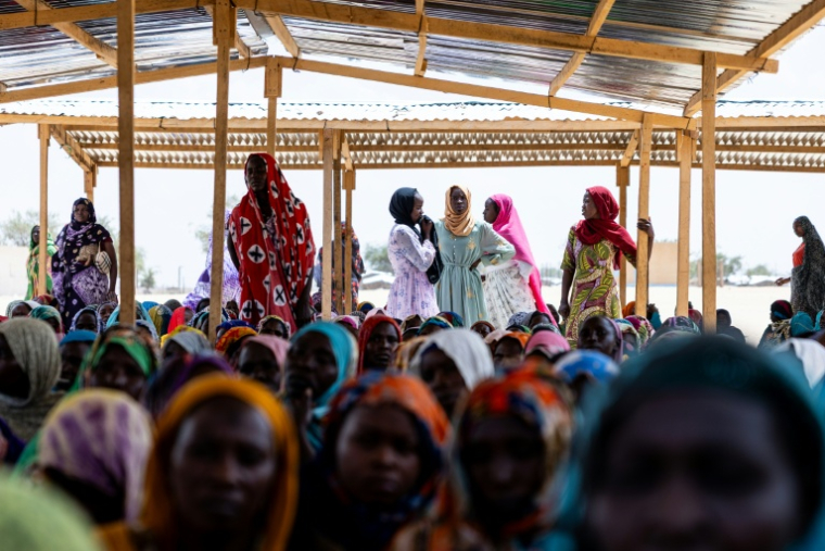 Des Tchadiens de retour au pays rencontrent une délégation de l'Organisation internationale pour les migrations (OIM) au camp de Tongori, le 9 juin 2026 au Tchad ( AFP / Joris Bolomey )