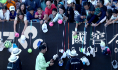 L'Espagnol Carlos Alcaraz (en bas) signe des autographes après avoir battu le Français Corentin Moutet au troisième tour de l'Open d'Australie, à Melbourne, le 23 janvier 2026 ( AFP / DAVID GRAY )