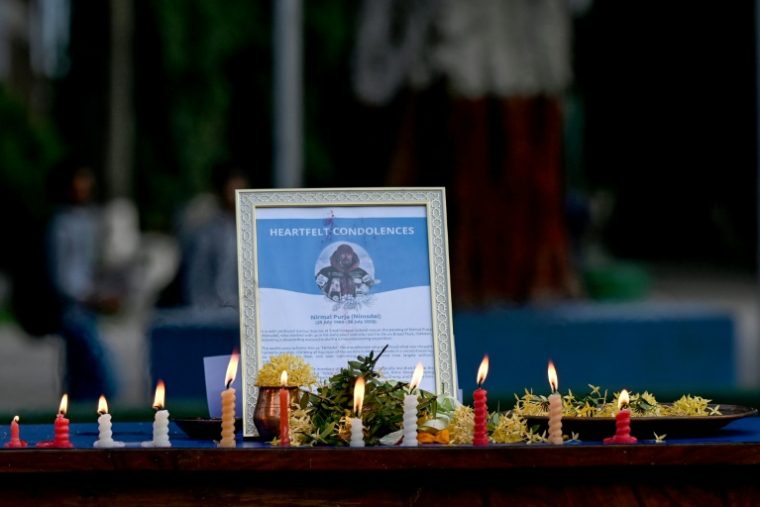Des personnes en deuil allument des bougies devant un portrait de l'alpiniste Nirmal Purja et présentent leurs condoléances après la mort de ce dernier et de ses compagnons dans une avalanche au Pakistan, à l'école Small Heaven de Chitwan, le 2 août 2026. Les secouristes ont retrouvé le corps du célèbre alpiniste Nirmal Purja le 2 août, après qu'une avalanche a causé sa mort ainsi que celle de neuf membres de son équipe sur l'un des plus hauts sommets du monde, dans le nord du Pakistan, a annoncé l'Alpine Club of Pakistan. ( AFP / Prakash MATHEMA )
