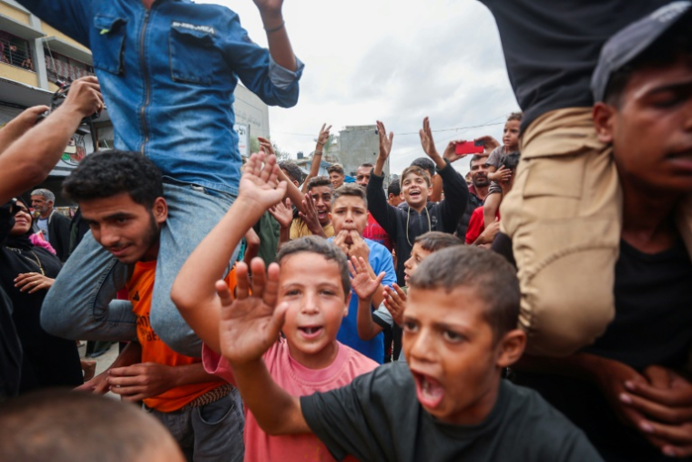 Des enfants palestiniens célèbrent à Khan Younès l'annonce d'un nouvel accord de cessez-le-feu dans la bande de Gaza, le 9 octobre 2025 ( AFP / Omar AL-QATTAA )