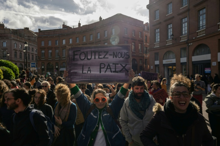 Une manifestante tient une pancarte sur laquelle on peut lire "Foutez-nous la paix" lors d'une marche marquant la Journée internationale des droits des femmes, à Toulouse, en Haute-Garonne, le 8 mars 2025 ( AFP / Ed JONES )