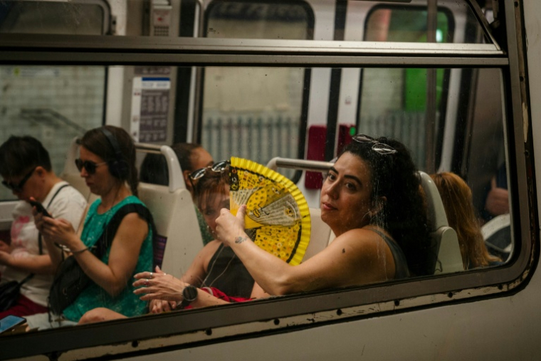 Une femme s'évente dans le métro parisien le 13 août 2025, en pleine vague de chaleur ( AFP / Dimitar DILKOFF )
