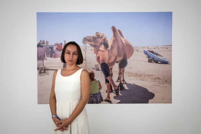 La photojournaliste arménienne Anush Babajanyan devant l'une de ses photos lors du festival Visa pour l'Image à Perpignan, le 2 septembre 2025 ( AFP / Valentine CHAPUIS )