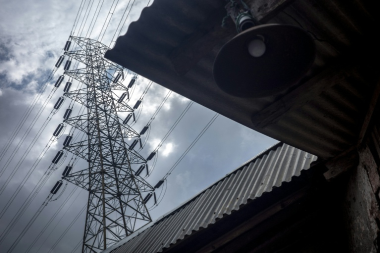 Un pylône à haute tension au-dessus de la maison d'un pêcheur, près de la centrale de Cirebon, en Indonésie, le 29 janvier 2026 ( AFP / BAY ISMOYO )
