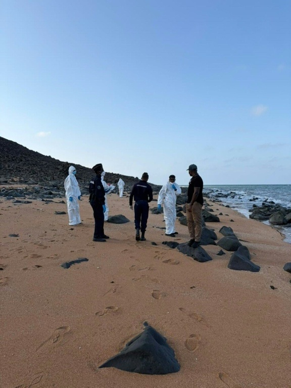 Photo diffusée par l’Organisation internationale pour les migrations (OIM) le 11 octobre 2026, montrant une équipe médico-légale et des membres des gardes-côtes djiboutiens inspectant une plage après un naufrage de bateau de migrants, à Obock (Djibouti) ( IOM / Handout )