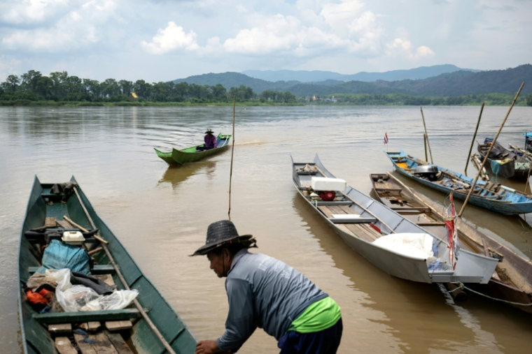 Le pêcheur Somdet Singthong pousse son bateau dans le Mékong, près de Chiang Saen, dans le nord de la Thaïlande, le 4 juin 2026 (  / Lillian SUWANRUMPHA )